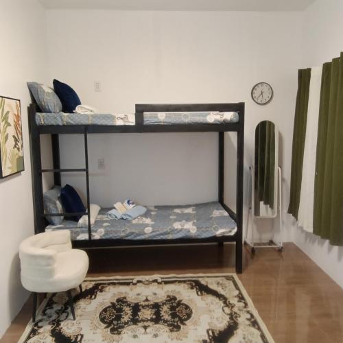 a room with two bunk beds and a chair at Love Bk Siargao Homestay in General Luna