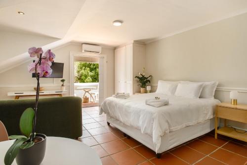 een slaapkamer met een groot wit bed en een tafel bij Story Haus in Stellenbosch