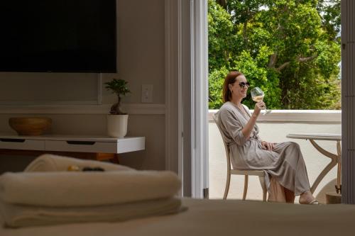 a woman sitting in a chair holding a glass of wine at Story Haus in Stellenbosch