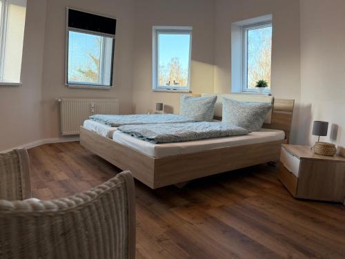 a bedroom with a bed and two windows at Ferienwohnung Bernsteinsucher städtische Bestlage in Ribnitz-Damgarten