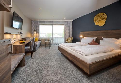 ein Schlafzimmer mit einem großen Bett und ein Wohnzimmer in der Unterkunft NaturKulturHotel Stumpf in Neunkirchen