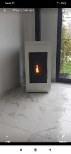 a small fireplace on the floor of a room at Chez Monique in Maubert-Fontaine