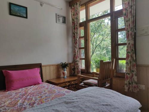 a bedroom with a bed with a pink pillow and a window at Nalze Khar in Raogi
