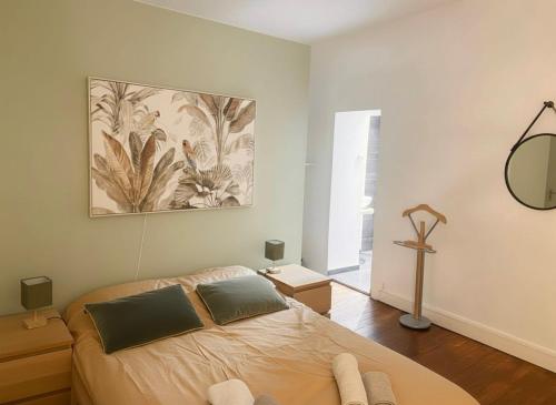 a bedroom with a bed and a painting on the wall at Grande maison centre ville in Laval