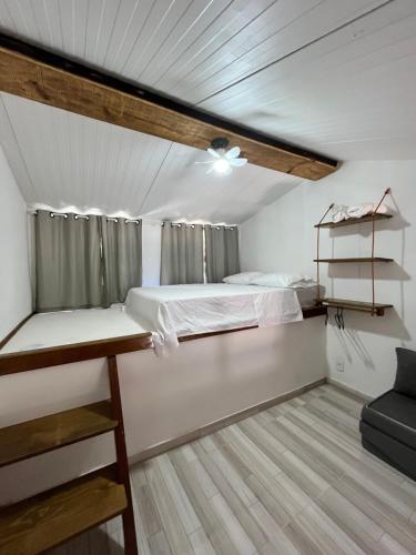 a room with two bunk beds and a couch at Casinhas da toca in Búzios