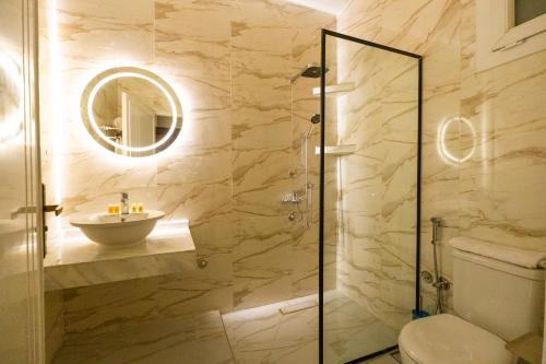 a bathroom with a shower and a toilet and a sink at Villa Ramses in Luxor