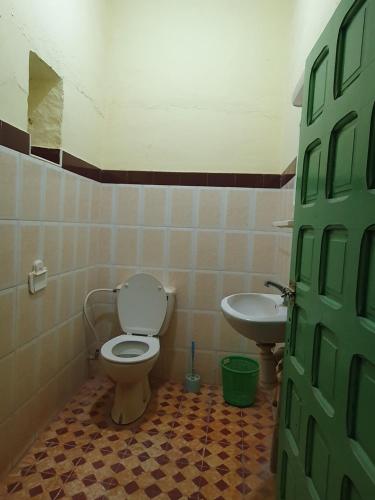 a bathroom with a toilet and a sink at Auberge camping la tradition in Merzouga
