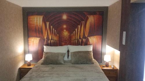 una camera da letto con un letto grande con un dipinto sul muro di Retiro dos Cedros - Quarto Adega a Fogueira