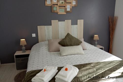 a bedroom with a large bed with towels on it at La Villa Des Raspes - Séjour Spa - Adult Only in Viala-du-Tarn
