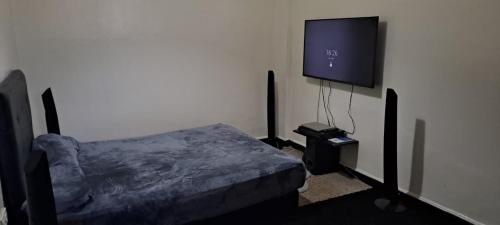 een slaapkamer met een bed en een flatscreen-tv bij Atlas Agdal Apartment in Rabat