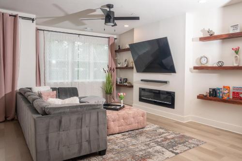 a living room with a couch and a flat screen tv at Luxury Urban Escape with Rooftop in downtown Atlanta in Atlanta