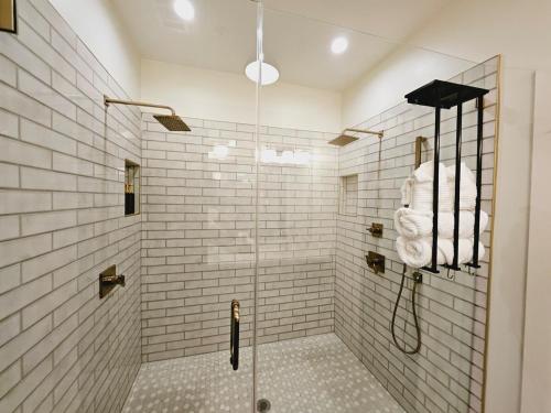 a bathroom with a shower with white tiles at Luxury Urban Escape with Rooftop in downtown Atlanta in Atlanta