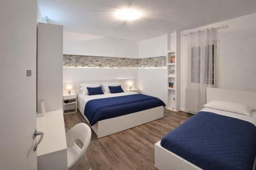 een hotelkamer met 2 bedden met blauwe lakens bij QUEEN HOME Emanuelle in Venetië