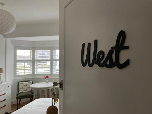 a bedroom door with the word west on the wall at 7 Goathill Crescent in Stornoway