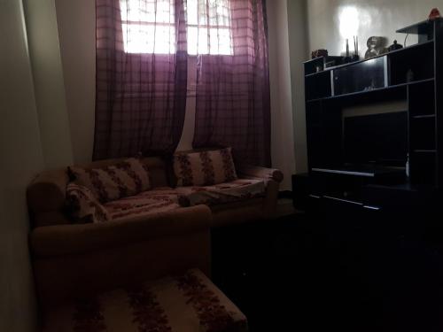 een woonkamer met een bank en een raam bij Atlas Agdal Apartment in Rabat