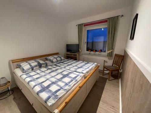a bedroom with a bed and a window at Ferienwohnung Heike Heitmann - Maisonette-Wohnung oder Apartment in Eystrup