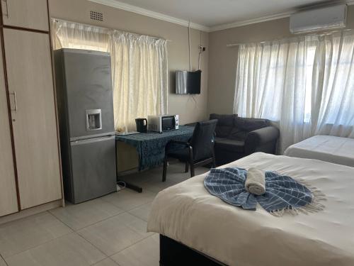 ein Hotelzimmer mit Bett und Schreibtisch in der Unterkunft Monica's Guesthouse in Welkom