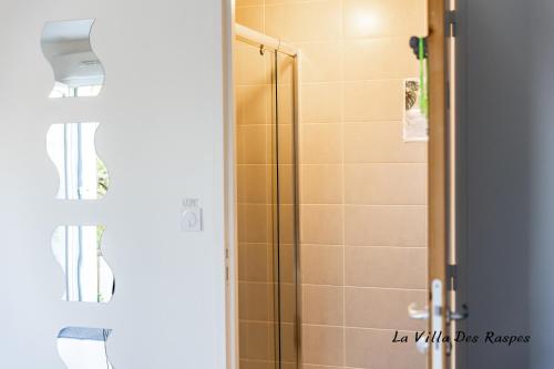 a bathroom with a shower with a glass door at La Villa Des Raspes - Séjour Spa - Adult Only in Viala-du-Tarn
