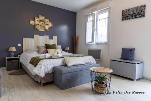 a bedroom with a bed and a blue ottoman at La Villa Des Raspes - Séjour Spa - Adult Only in Viala-du-Tarn