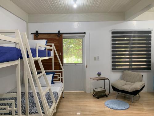 a bedroom with two bunk beds and a chair at Mountain View Anilao in Mabini