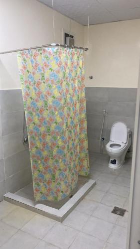 a shower curtain in a bathroom with a toilet at Alharamil Retreat in Ras al Khaimah