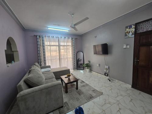 een woonkamer met een bank en een tafel bij Flynn Stays in Bamburi
