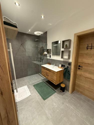 un bagno con lavandino e doccia di Appartement Bergsicht a Leogang