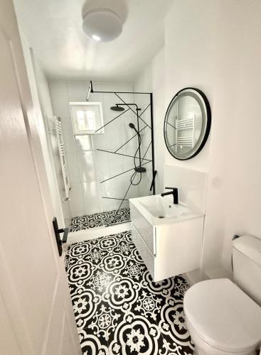 a white bathroom with a sink and a mirror at TwinNest Petrila in Petrila
