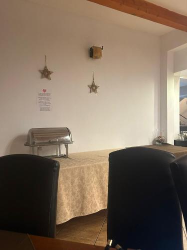een wachtkamer met een tafel en twee stoelen bij Hotel Ana in Bran