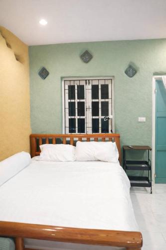 a bedroom with a large white bed and a window at Earth House HomeStay Bangjo in Ban Pak Lak