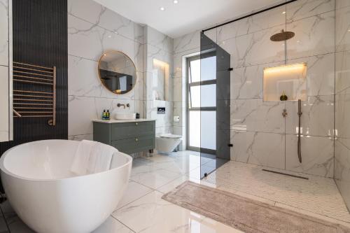 a bathroom with a large tub and a shower at Pinnacle Villa in Plettenberg Bay