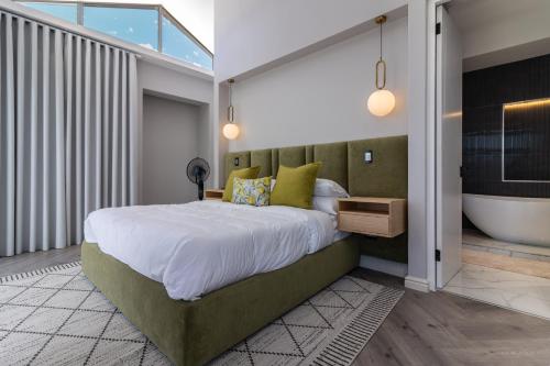 a bedroom with a large bed and a bath tub at Pinnacle Villa in Plettenberg Bay