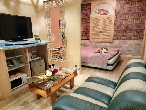 a living room with a couch and a bed and a mirror at openHeart城『キャッスル』 in Ōami