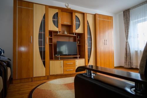 a living room with a television and wooden cabinets at House Dey in Făgăraş