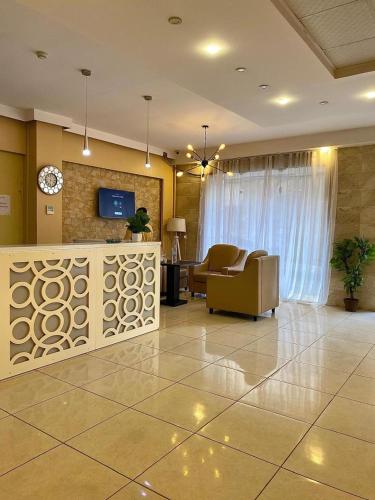 een lobby met een woonkamer met een bank en een tv bij Hotel kssar in Oran