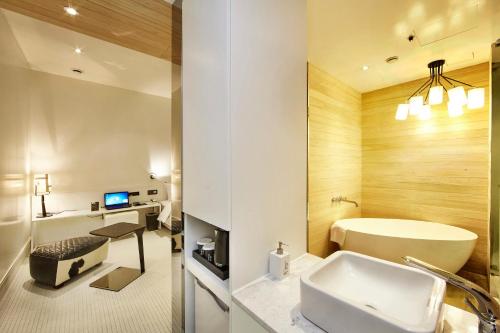 a bathroom with a tub and a sink and a toilet at Hotel Soulhada Gangnam in Seoul