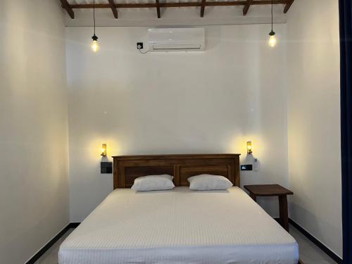 a bedroom with a bed with two pillows on it at Lio Villa in Habaraduwa Central