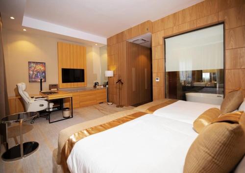 una camera d'albergo con un letto grande e una scrivania di Atlantiis Suites Inn Mahmoorganj Near Vishwanath Temple a Varanasi