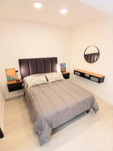 a bedroom with a large bed and a mirror at Departamentos Necochea Playa in Necochea