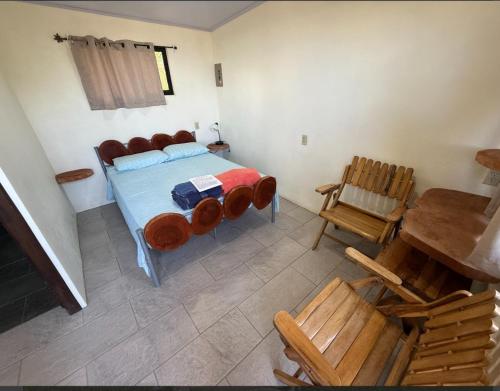 a bedroom with a bed and a wooden chair at Sunset Farms and Waterfalls! in Tilarán