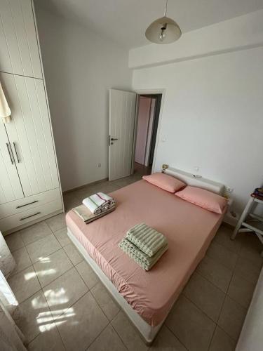 a bedroom with a large pink bed with pink pillows at Parostalkinghouse in Piso Livadi