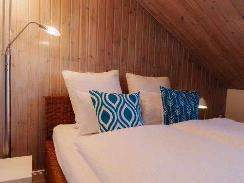 a bedroom with a bed with blue and white pillows at Chalet Flandesbach in Velbert