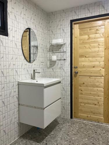 a bathroom with a white sink and a mirror at Mae on country home in Ban On Luai