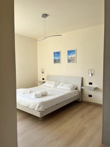 a bedroom with a large bed with white sheets at Casa L'Oliver in Limone sul Garda