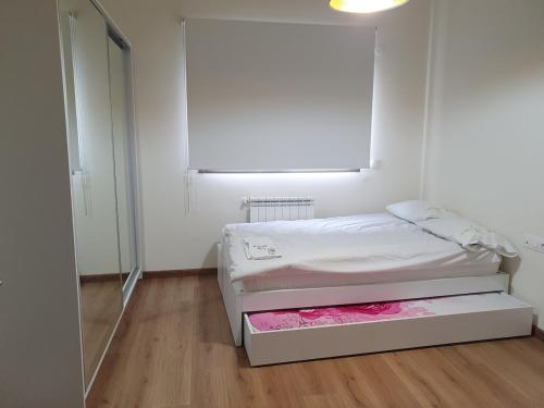 a white room with a bed and a mirror at Lucas Apart 2Bdr & 2Bth with pool in Mār Yūsuf