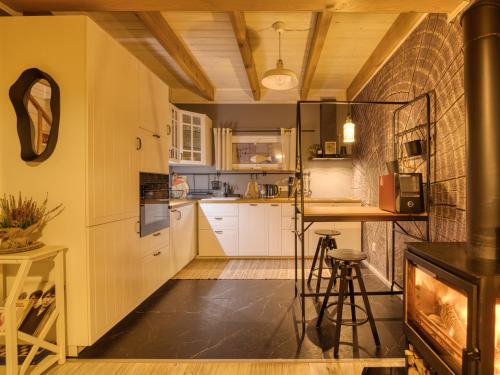 a kitchen with white cabinets and a fireplace at GłuszaSpot Dom Odyn in Bytoń