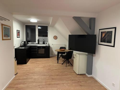 a kitchen with a table and a tv on a wall at Luxus Ferien Apartment vS in Marburg an der Lahn