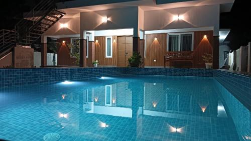 una piscina davanti a una casa di notte di Captain's Castle a Pallipuram