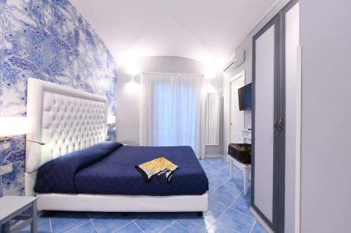 ein blau-weißes Schlafzimmer mit einem Bett und einem Fernseher in der Unterkunft Appartamenti Amalfi Centro Storico in Amalfi
