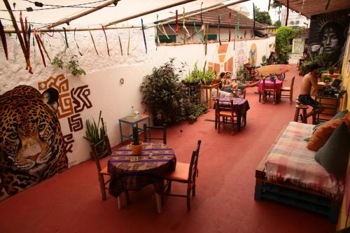 een restaurant met tafels en stoelen en een muur met graffiti bij La Chakana Hostel Cultural in Ubatuba